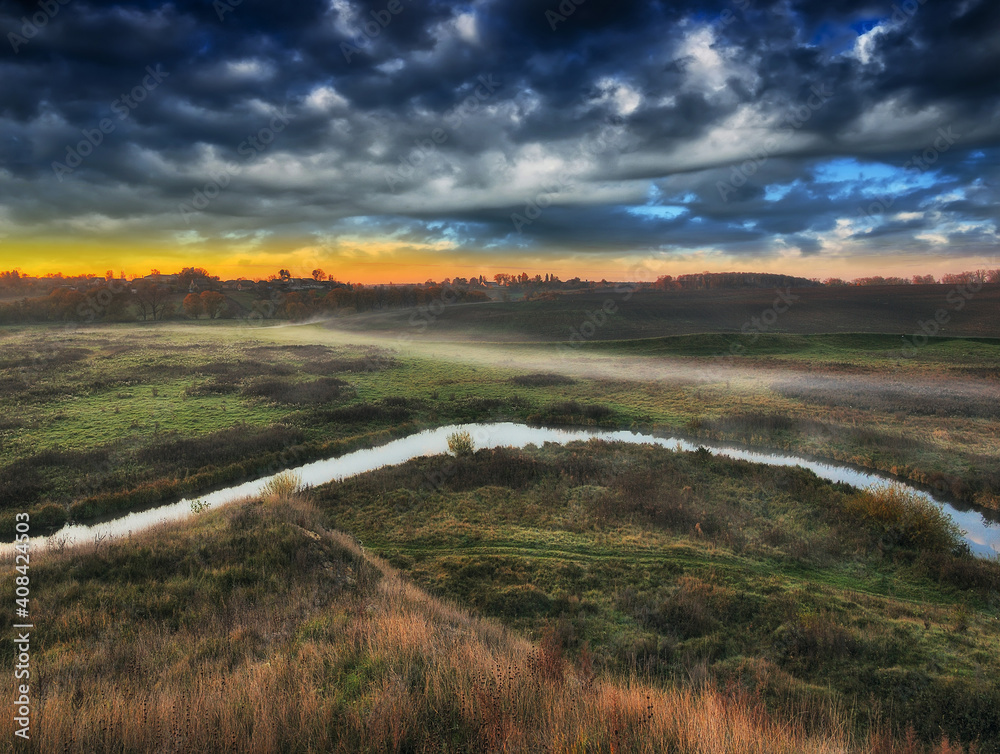 picturesque clouds over the river. autumn sunrise in the meadow