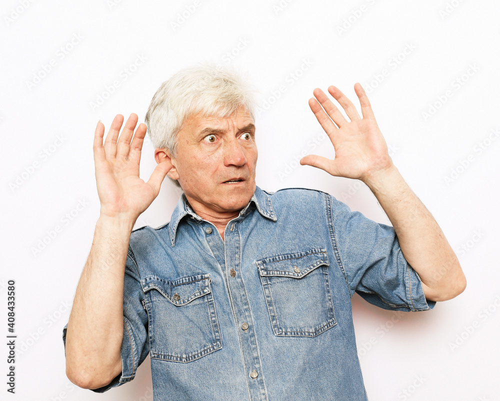 portrait senior mature man, looking shocked, scared trying to protect himself in anticipation of unpleasant situation, isolated white background. Negative emotion facial expression feeling portrait senior mature man, looking shocked, scared trying to protect himself in anticipation of unpleasant situation, isolated white background. Negative emotion facial expression feeling