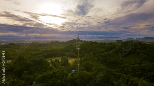 Cinematic hyperlapse Aerial footage circle view of 5G Communication tower during morning sunrise with clouds, mists and fog