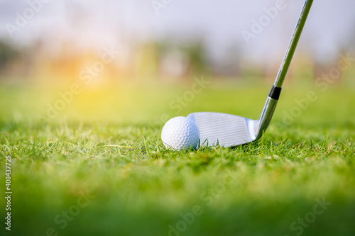 Golf clubs and golf balls on a green lawn in a beautiful golf course with morning. Sport to relieve tension and stimulate the brain function.