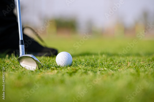 Golf clubs and golf balls on a green lawn in a beautiful golf course with morning. Sport to relieve tension and stimulate the brain function.