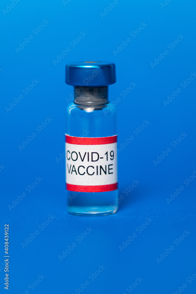 Vial filled with Covid-19 vaccine on blue background. Vial filled with Covid-19 vaccine on blue background.