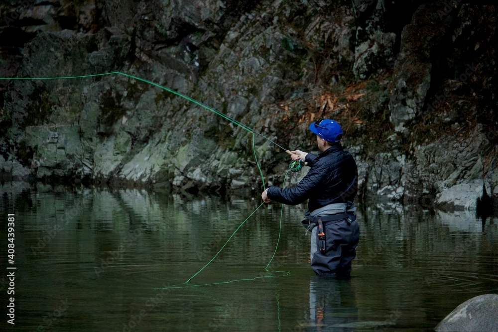 North Vancouver, British-Columbia - Canada - 09-23-2018: A Fly Fisherman casts his line for a fish on the Capilano River, hoping for a steelhead, salmon or trout North Vancouver, British-Columbia - Canada - 09-23-2018: A Fly Fisherman casts his line for a fish on the Capilano River, hoping for a steelhead, salmon or trout