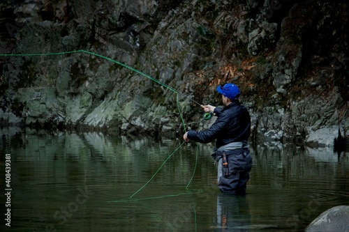 North Vancouver, British-Columbia - Canada - 09-23-2018: A Fly Fisherman casts his line for a fish on the Capilano River, hoping for a steelhead, salmon or trout
