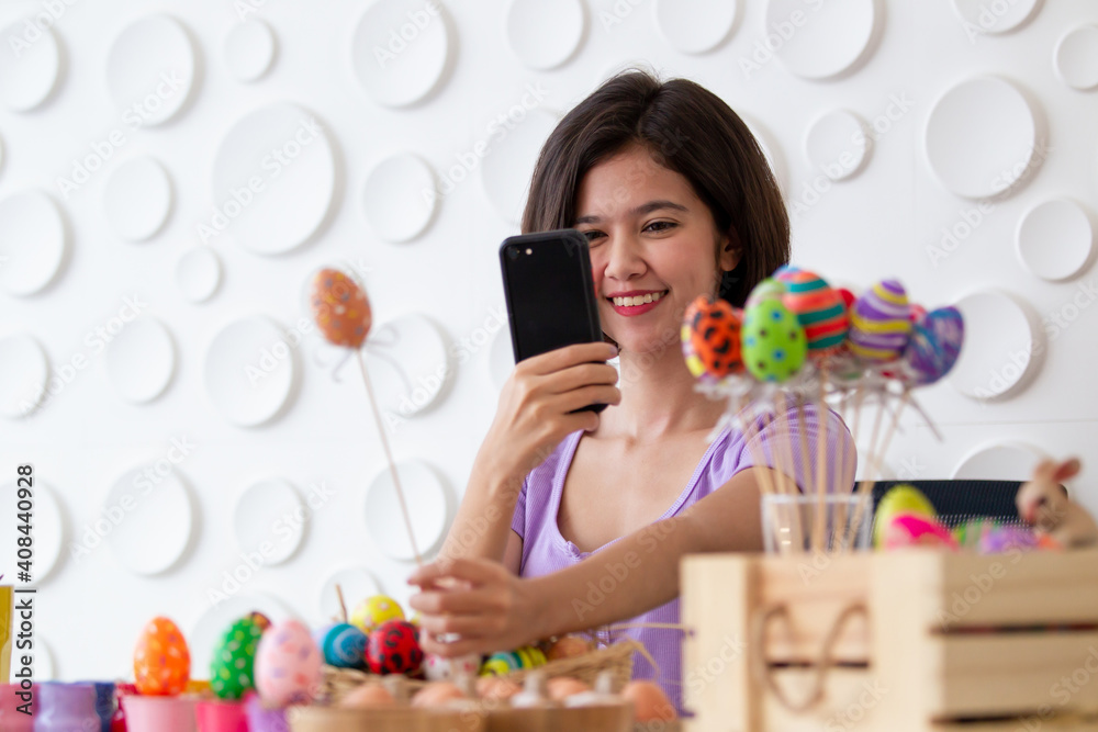 Asian young pretty woman enjoy painting a water colors on fantasy eggs for Easter egg festival.