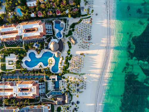 Aerial drone view of beach resort hotels with pools, umbrellas and blue water of Atlantic Ocean, Bavaro, Punta Cana, Dominican Republic