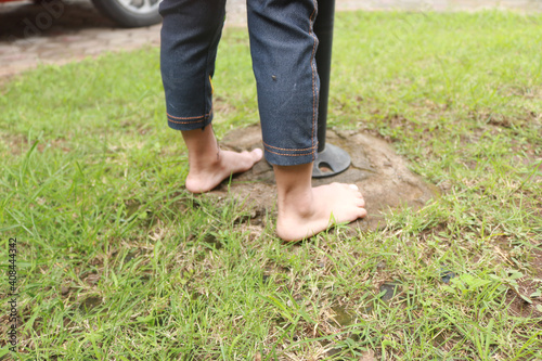 Two small children's feet stepped on the grass in the garden.