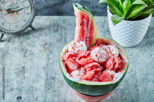 Ice-cream inside watermelon and clock, pot with plant photo