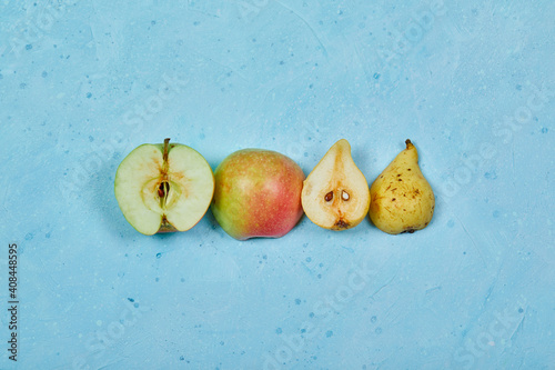 Half cut apple and pear isolated blue background