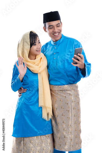muslim couple using mobile phone isolated over white background