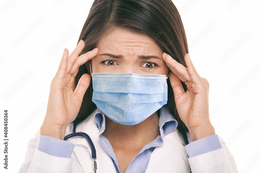 Doctor wearing coronavirus surgical face mask in panic scared doing a funny stressed out facial expression holding head from headache. Asian woman portrait. Doctor wearing coronavirus surgical face mask in panic scared doing a funny stressed out facial expression holding head from headache. Asian woman portrait.