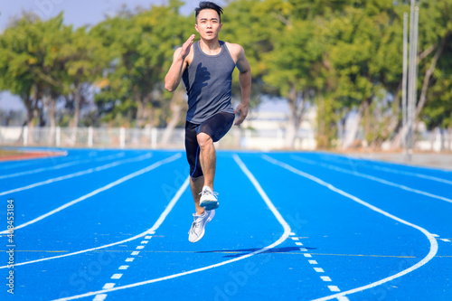 young asian man athlete running and training on the track