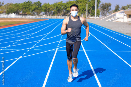 Man in medical mask and running  on the track