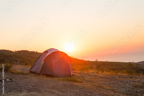 Installed tourist tent in the mountains with a view of the sea and sunrise. Domestic tourism, active summer trip, family adventures. Ecotourism, camping, sports mountain hiking. Ayu-Dag, Crimea.