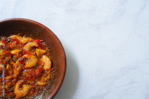 a plate of prawn cooked in sambal in an earhenware plate named gami udang is an Indonesian cuisine from Bontang, Borneo. photo