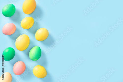 Beautiful colorful easter eggs on blue background. Happy Easter. Congratulatory easter background. Pastel Easter eggs on blue background top view. Flat lay style.