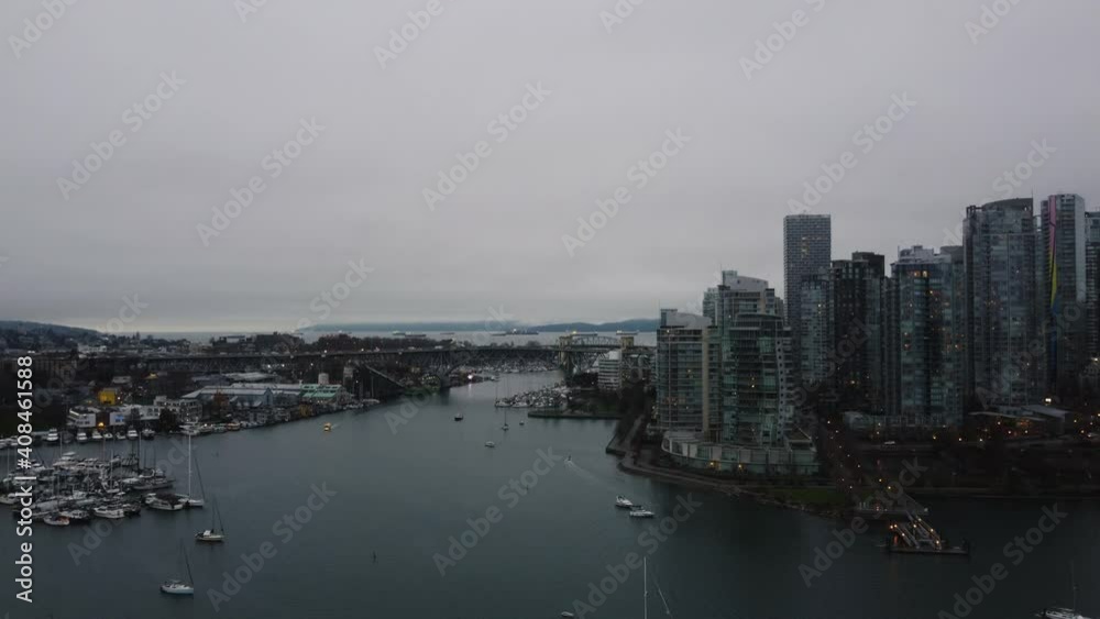 Gray Vancouver downtown with the view on the bridge and cargo ships in the bay