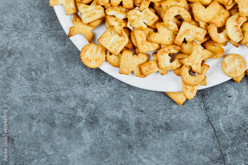 A plate of alphabet crackers on a marble background