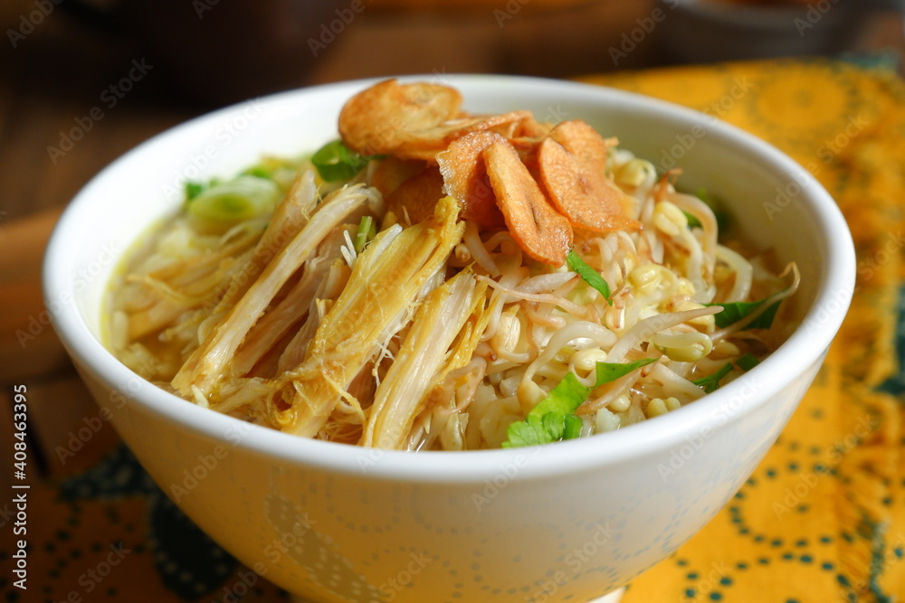 a bowl of Indonesian clear soup named soto Kudus, it contains of rice, vegetables and chicken meat a bowl of Indonesian clear soup named soto Kudus, it contains of rice, vegetables and chicken meat