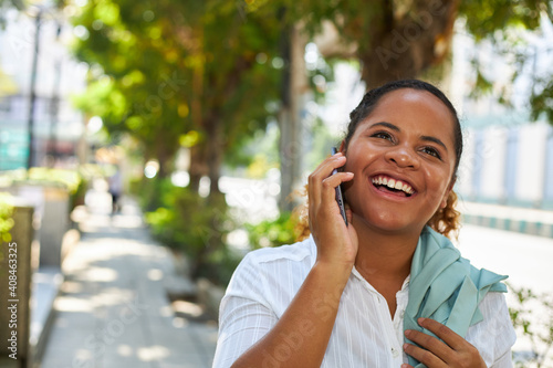 An African American woman is cheerful on the phone.