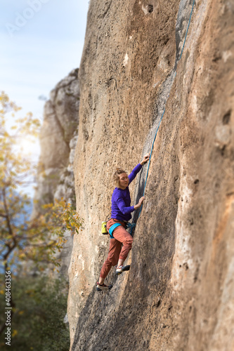 girl climbs a rock-climbing route. outdoor sports. © zhukovvvlad