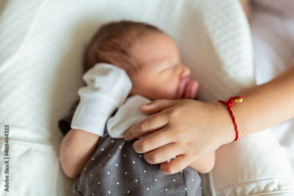 Newborn Baby in white cocoon. Sister holding newborn baby. health care, hygiene, happy family concept Newborn Baby in white cocoon. Sister holding newborn baby. health care, hygiene, happy family concept