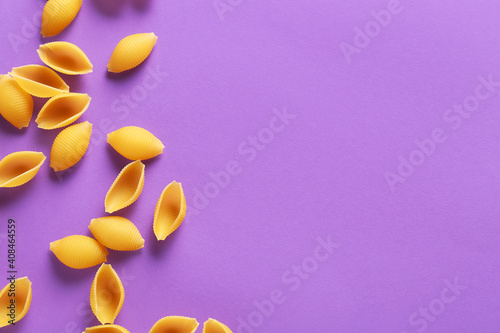Dry conchiglie pasta on color background