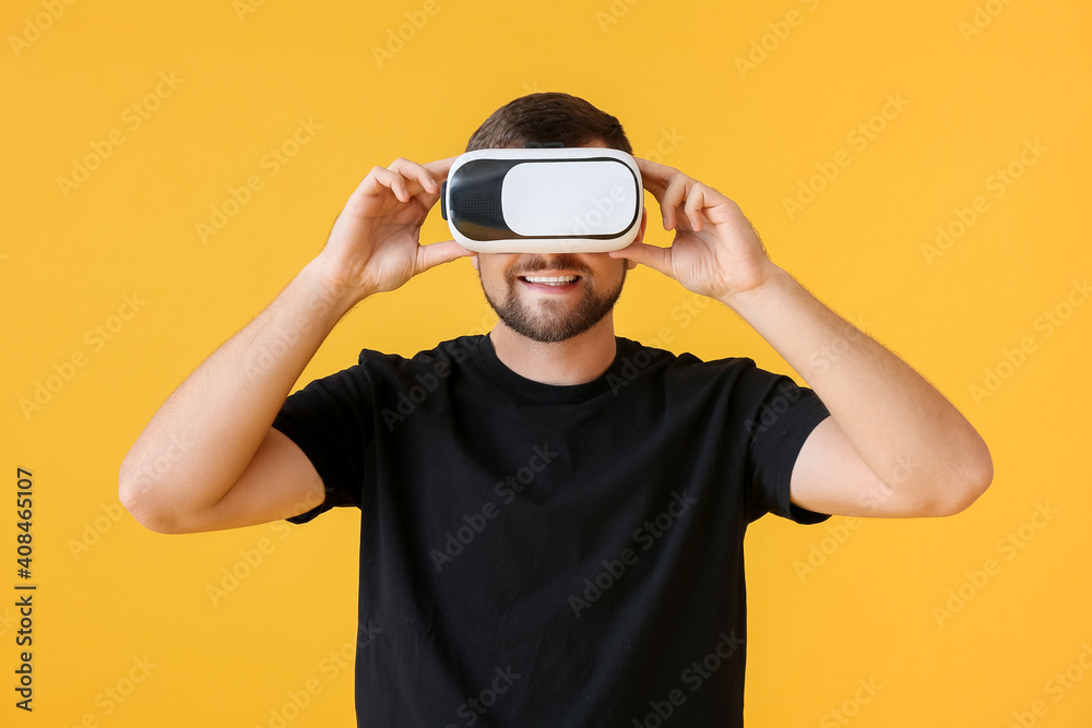 Young man with virtual reality glasses on color background Young man with virtual reality glasses on color background