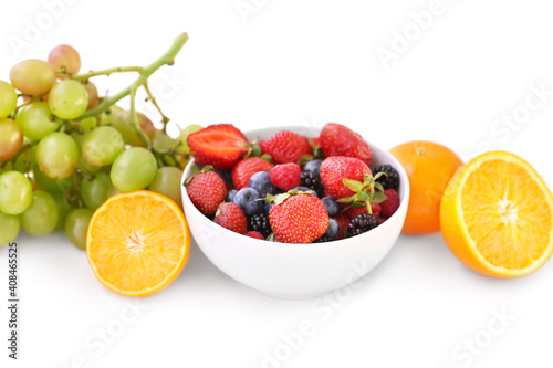 Bowl with different berries and fruits on white background