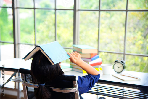 Tired Girlholding a book over his head.The concept of pre-school education. Education photo