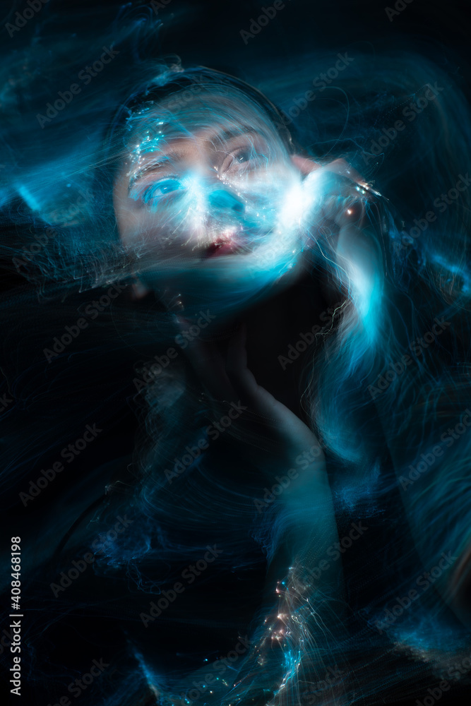 Portrait of young woman amid light painting , Over Black Background. Long exposure photo without photoshop, light drawing at long exposure Portrait of young woman amid light painting , Over Black Background. Long exposure photo without photoshop, light drawing at long exposure