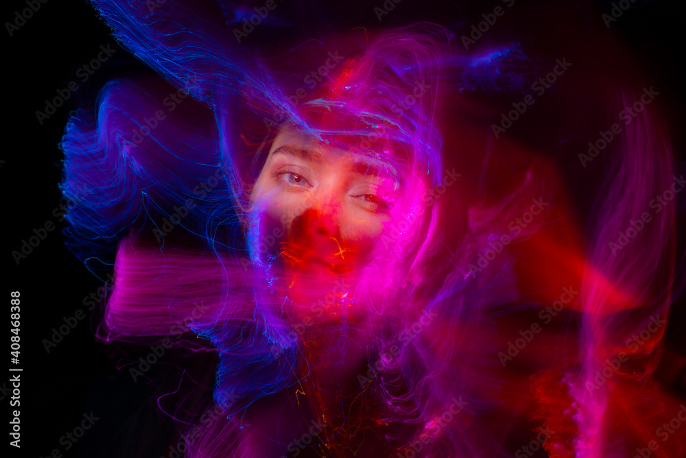 Portrait of young woman amid light painting , Over Black Background. Long exposure photo without photoshop, light drawing at long exposure Portrait of young woman amid light painting , Over Black Background. Long exposure photo without photoshop, light drawing at long exposure