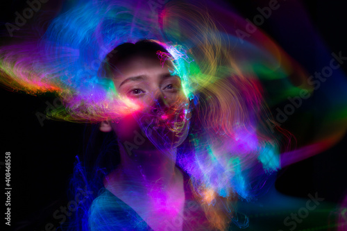Portrait of young woman amid light painting   Over Black Background. Long exposure photo without photoshop  light drawing at long exposure