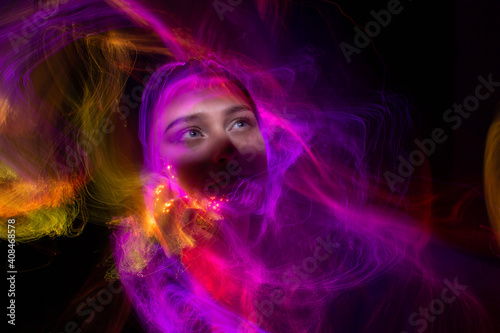 Portrait of young woman amid light painting   Over Black Background. Long exposure photo without photoshop  light drawing at long exposure