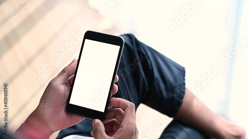Mockup image of man hands holding mobile phone with blank white screen. Blank screen for advertise text.
