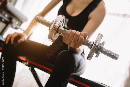 Determined woman losing weight at home and exercising with dumbbells. Sport and recreation concept. Beautiful woman © Nuttapong punna