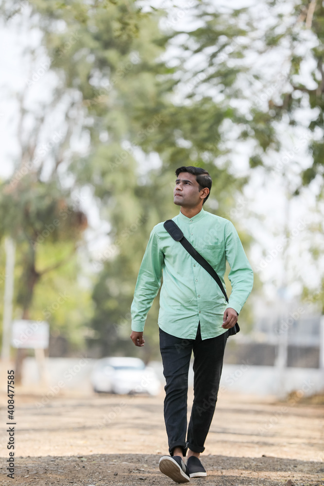 Young Indian male model standing and holding the office bag and giving expression. Young Indian male model standing and holding the office bag and giving expression.