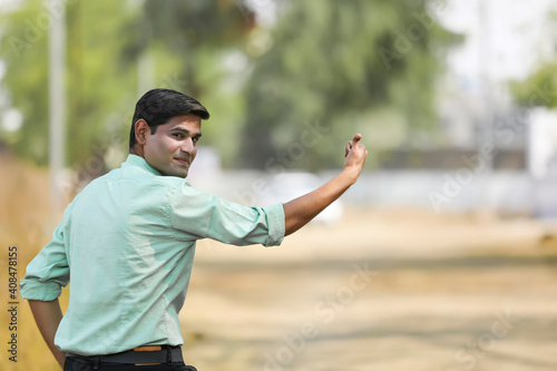 Young indian man asking lift for going to home