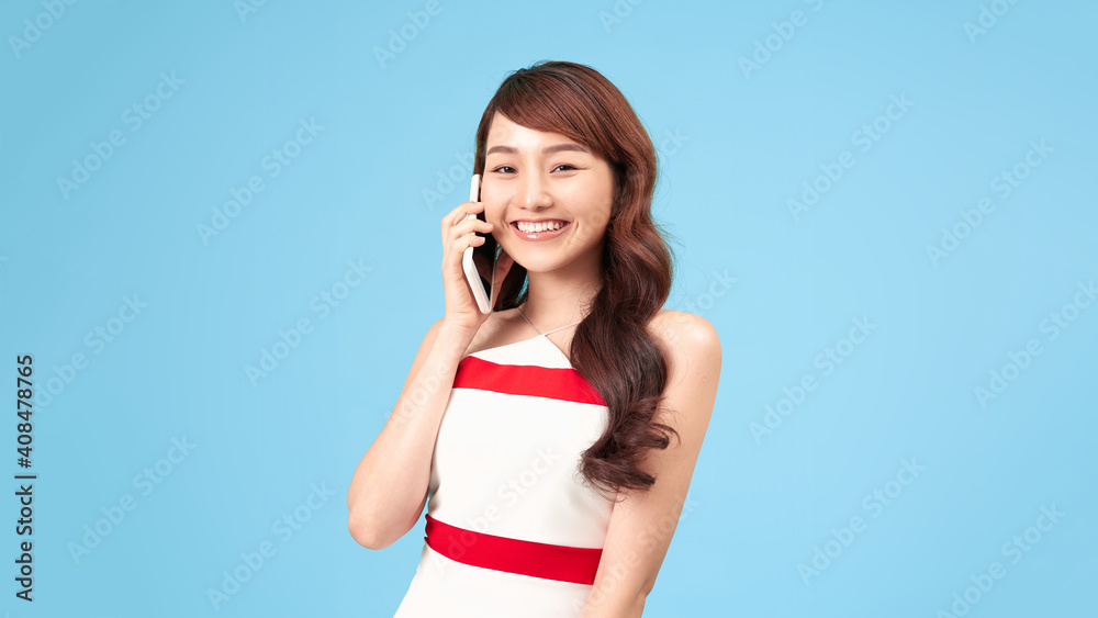 An attractive smiling girl speaks on mobile phone An attractive smiling girl speaks on mobile phone