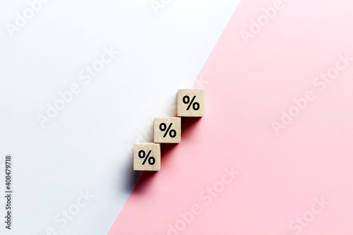 Fotografia Wooden blocks stacking as step stair with percent or percentage symbol on pink and white background