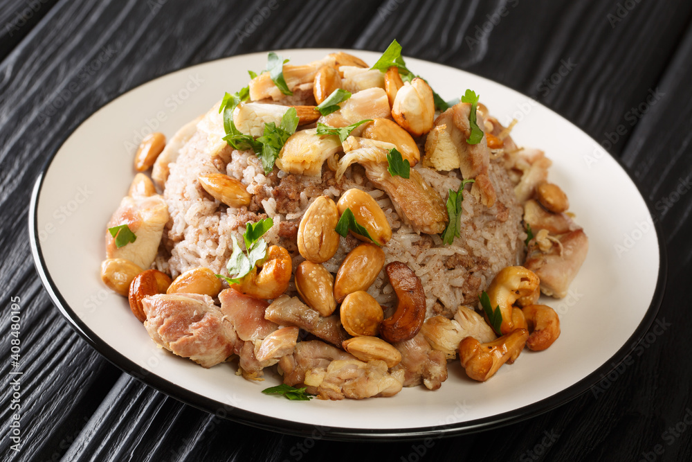 Festive Lebanese dish Riz bi-Djaj rice with cinnamon, chicken and nuts close-up in a plate on the table. horizontal Festive Lebanese dish Riz bi-Djaj rice with cinnamon, chicken and nuts close-up in a plate on the table. horizontal