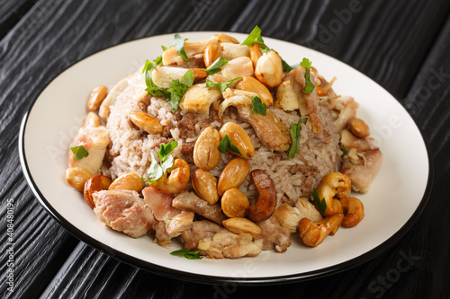 Festive Lebanese dish Riz bi-Djaj rice with cinnamon, chicken and nuts close-up in a plate on the table. horizontal