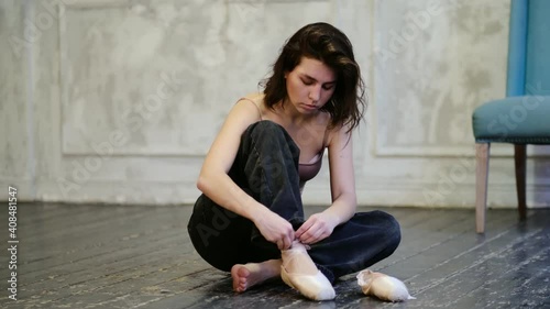 modern dancer in jeans puts on pointe shoes, classical and modern style concept in art. Slow motion video. stock footage photo