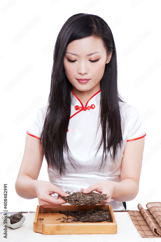 Wear cheongsam Oriental young female holding a Pu'er brick tea Wear cheongsam Oriental young female holding a Pu'er brick tea