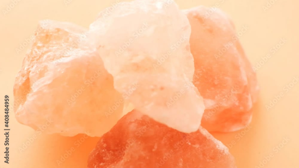 Pink Himalayan salt lumps close-up on an orange background. Pink Himalayan salt lumps close-up on an orange background.