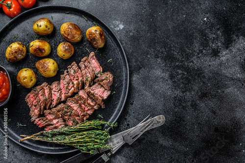 Grilled marble meat beef Steak with fried potato. Black background. Top view. Copy space