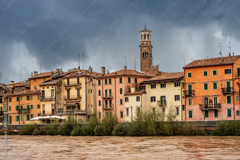 The River Adige in flood in Verona downtown after several violent storms. In the background the Lamberti Tower (Torre dei Lamberti, XI century-1403). UNESCO heritage site, Veneto, Italy, Europe.