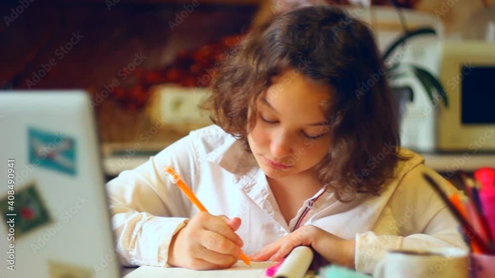 curly schoolgirl studying at home with laptop. social distance during quarantine curly schoolgirl studying at home with laptop. social distance during quarantine