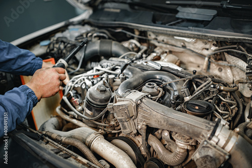 Auto mechanic man checks car engine under the hood © fotofabrika