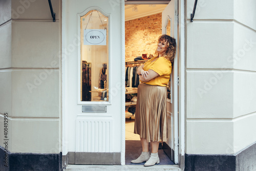 Businesswoman standing at her boutique doorway